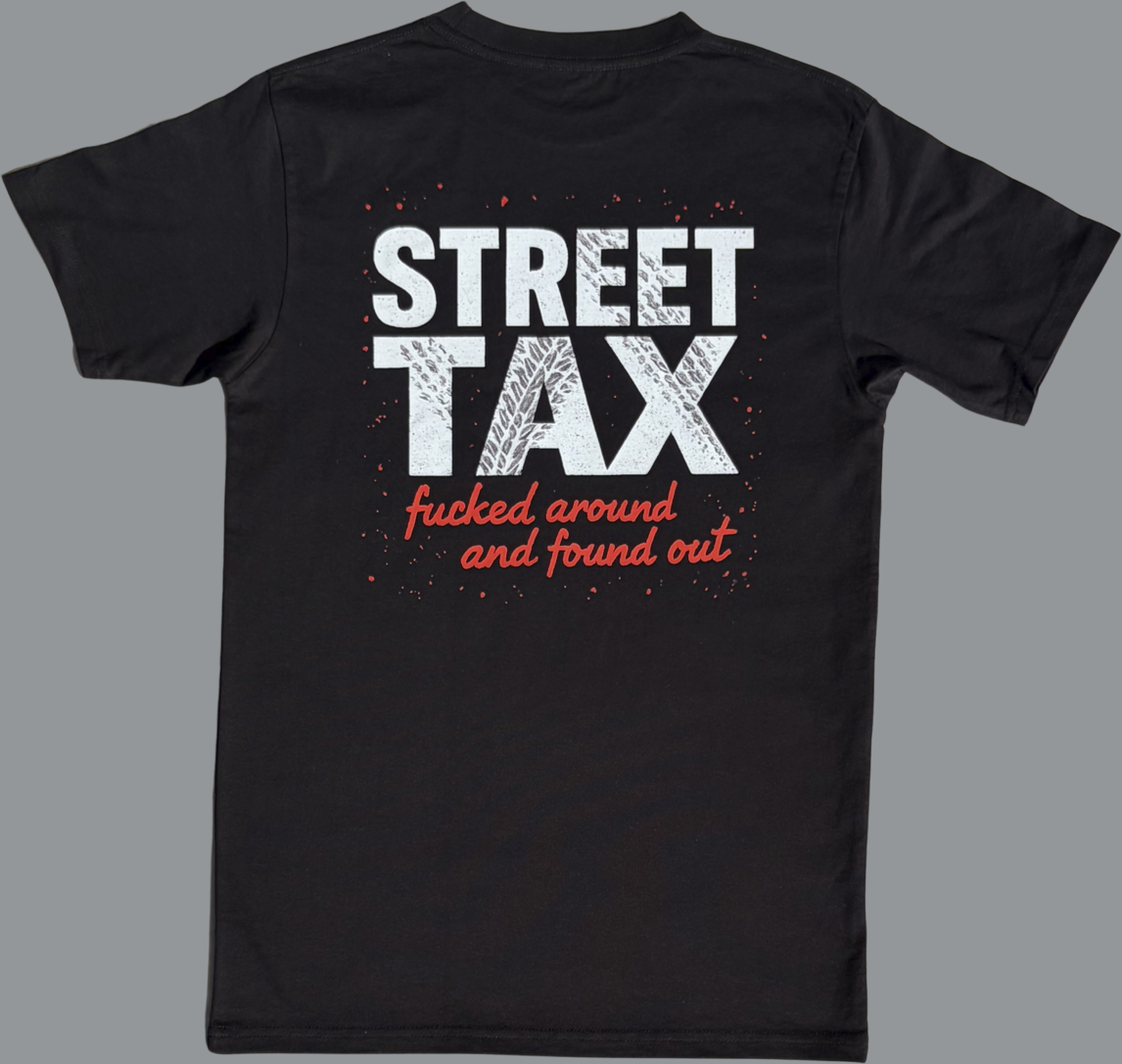 Black short sleeve t-shirt featuring a large graphic printed across the upper back. The design includes the words “STREET TAX” in bold white capital letters with a distressed texture. Below it, in smaller red script, the text reads “fucked around and found out.” The graphic also includes red paint splatter accents around the text. The rest of the shirt is plain black.