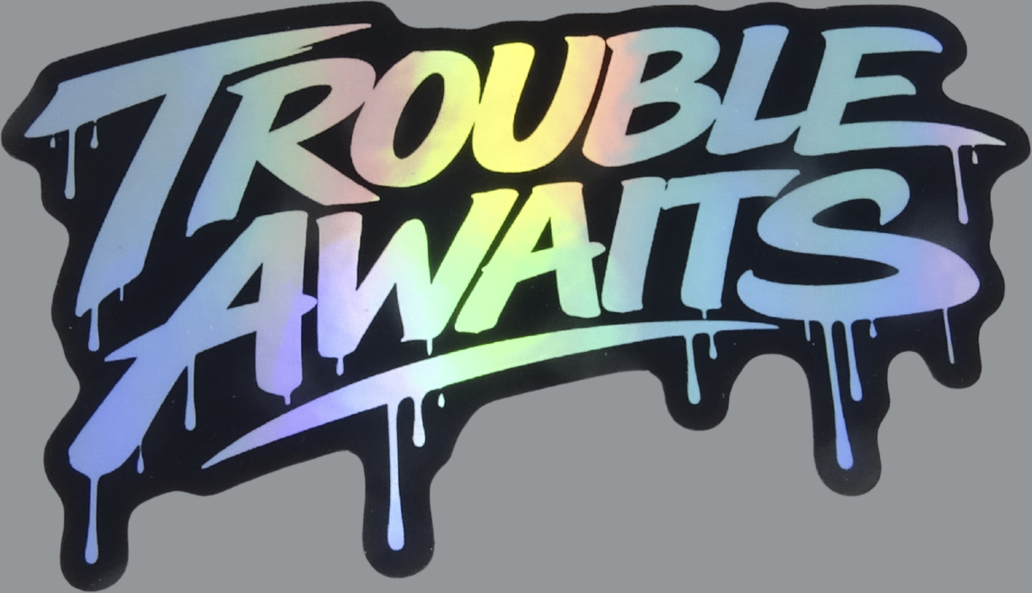 A die-cut sticker featuring the words “Trouble Awaits” in a bold, graffiti-style font. The lettering has a holographic gradient finish that shifts between soft rainbow tones, including blue, green, yellow, and purple, depending on the light. The text is outlined with a black border, making the shape of the sticker stand out clearly. Paint-drip details extend downward from several letters, giving it a street-art, spray-painted look. The overall design has a glossy, reflective appearance 