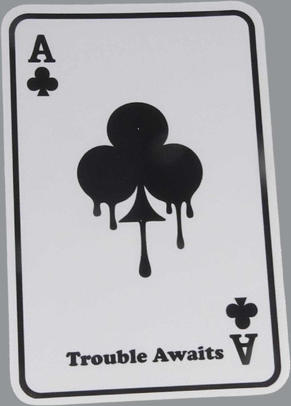 A rectangular sticker designed like a playing card, displayed against a neutral gray background. The card is white with a thin black border and rounded corners. In the top left corner is the letter “A” and a small club symbol, indicating the Ace of Clubs. In the center of the card is a large black club symbol with a dripping paint effect, where the edges of the shape extend downward like liquid. In the bottom right corner, the card is mirrored with an upside-down “A” and club symbol. 